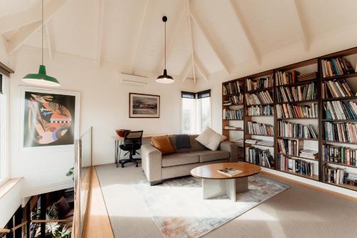 a living room with a couch and a table at A Stylish and Unique Retreat at Surf Beach in Surf Beach