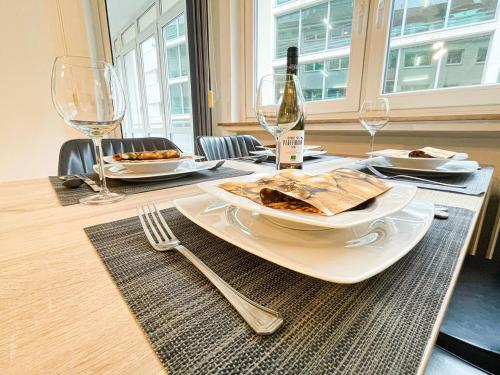 einen Tisch mit einem Teller mit Speisen und Weingläsern in der Unterkunft Ambiente Apartment in Bremen