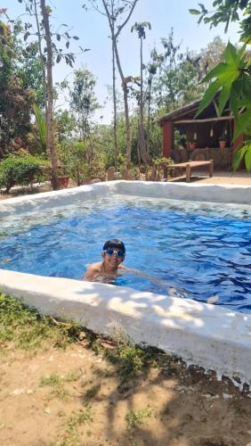 a boy in a swimming pool with sunglasses on at Bastar Birds Nest 