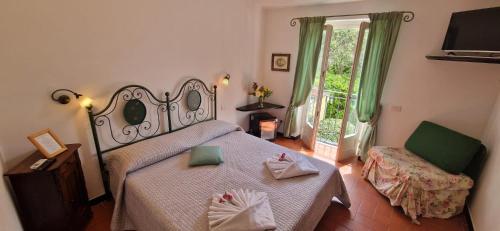 a bedroom with a bed and a chair and a window at Hotel La Giada del Mesco in Levanto