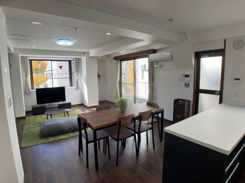 een woonkamer met een tafel, stoelen en een bank bij 洗足21 in Tokyo