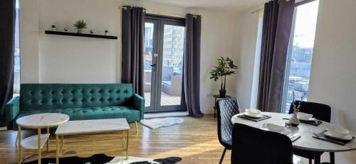 a living room with a green couch and a table at Manchester Penthouse - 2 Bedroom Apartment in Manchester
