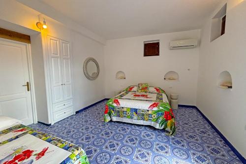 a bedroom with two beds and a blue floor at Casa Ambra in Panarea