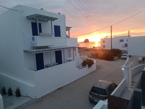 a building with a car parked in front of a sunset at Zen Milos Green Apple in Pollonia