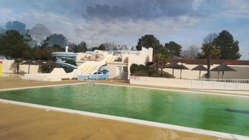 un complexe avec une piscine et un toboggan. dans l'établissement Superbe Mobil home 3 chambres F51, à Saint-Jean-de-Monts