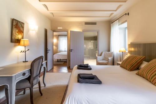 a bedroom with a bed and a desk and a room at Mas Dalia - Turismo Rural - Girona - Monells, Empordà in Monells