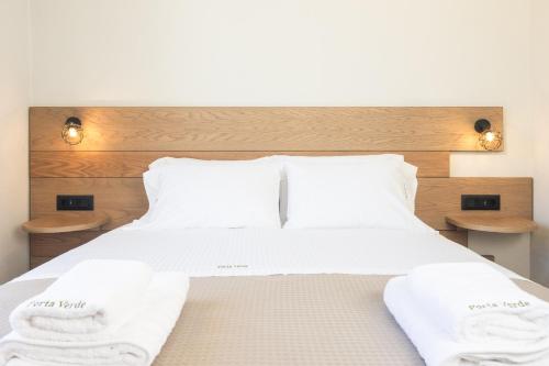 a bedroom with a bed with white sheets and towels at Porta Verde Luxury Residence, By TK Property Management in Laganas