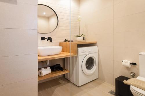 a bathroom with a washing machine and a sink at Porta Verde Luxury Residence, By TK Property Management in Laganas