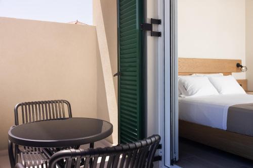 a small room with a bed and a table and chair at Porta Verde Luxury Residence, By TK Property Management in Laganas