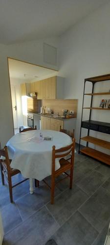 una cocina con una gran mesa blanca y 2 sillas en La maisonnette cherbourgeoise en Cherbourg en Cotentin