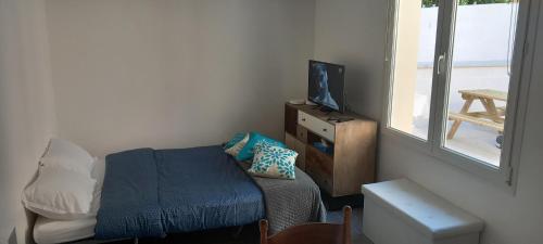 1 dormitorio pequeño con 1 cama y TV en La maisonnette cherbourgeoise, en Cherbourg-en-Cotentin