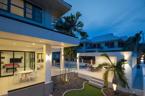a villa with a swimming pool at night at Stunning villa with pool and tropical garden in Hua Hin