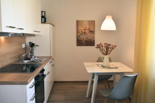a small kitchen with a table and a vase of flowers at Apartment Ferientiet in Bergen auf Rügen