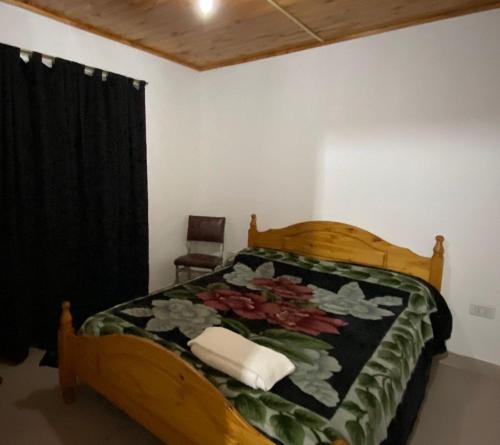 um quarto com uma cama de madeira e uma cortina preta em Casa estilo Americana Bruno - a 15 min del Aeropuerto em Barrio Esteban Echeverría