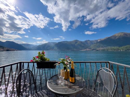a table and chairs on a balcony overlooking a lake at Appartamento Try on Lake Como with Balcony in Lezzeno
