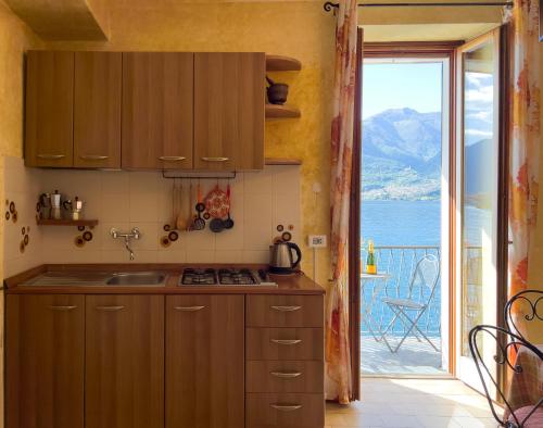 cocina con fregadero y vistas al océano en Appartamento Try on Lake Como with Balcony, en Lezzeno