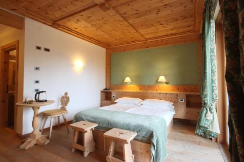 1 dormitorio con 1 cama grande y 1 mesa en Ciasa Vervei, en Cortina dʼAmpezzo