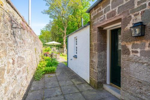 an alleyway leading to a building with a door at Binrock Lodge in Dundee