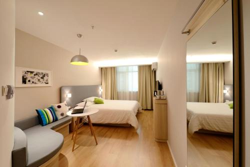 ニューデリーにあるHotel Atlantis suites Near Delhi Airportのベッド2台とソファが備わるホテルルームです。