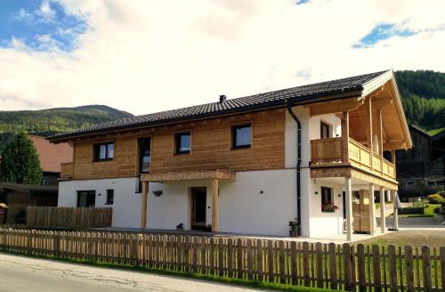 a house with a wooden fence in front of it at Apartments Haufhof , Haus im Ennstal bei Schladming in Haus im Ennstal
