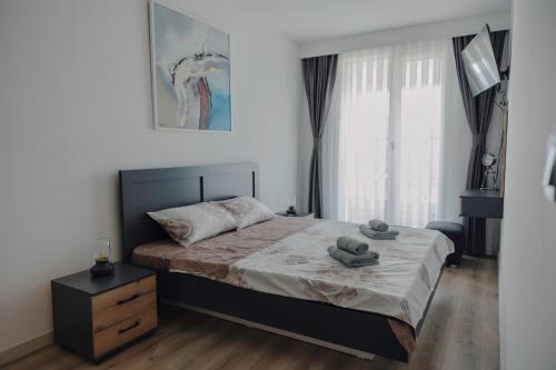 a bedroom with a bed with two towels on it at 33rd Floor Twin Apartments & 7th Floor Apartment In Cevahir Sky City Complex With Pool, Spa, Fitness and Parking Included In Price in Skopje