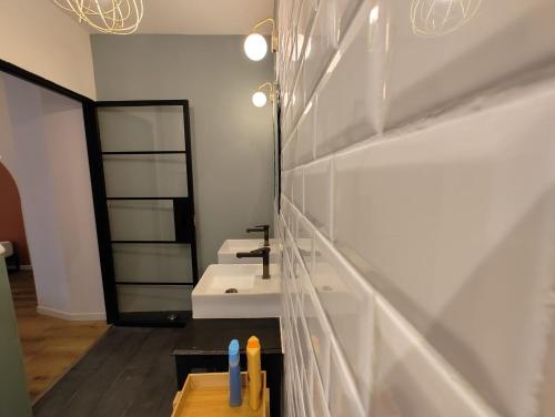 une salle de bain avec deux lavabos et un miroir dans l'établissement Charmant logement avec 2 chambres jusqu'à 6 voyageurs proche centre ville, à Lourdes