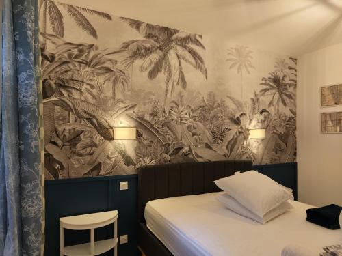 Cette chambre comprend un lit et un mur orné d'une fresque murale. dans l'établissement Charmant logement avec 2 chambres jusqu'à 6 voyageurs proche centre ville, à Lourdes