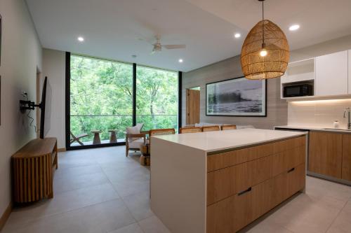 a kitchen with a large island and a large window at 2-Bedroom Jungle View Penthouse with Pool & Jacuzzi in Nosara