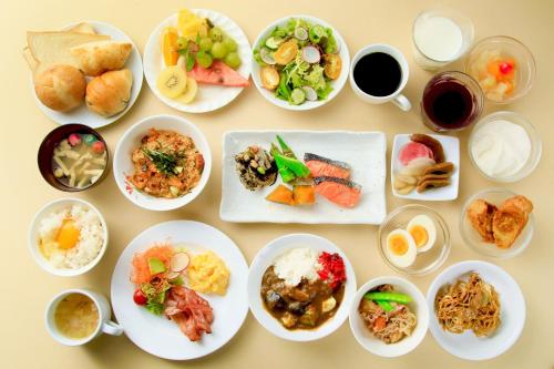 a table with many plates of food on it at Richmond Hotel Narita in Narita