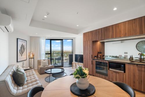 a living room with a couch and a table at Greenhouse Apartments by Urban Rest in Auckland