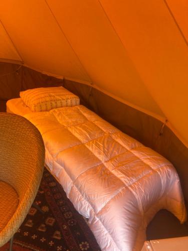 a bed sitting inside of a tent at Bell tent Binnen Duin in 't Horntje