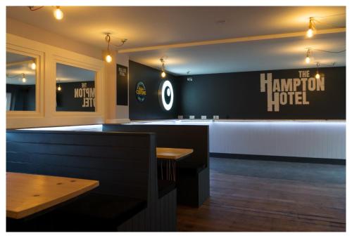 a bar in a restaurant with a sign on the wall at Hampton Hotel & restaurant in Llandrindod Wells