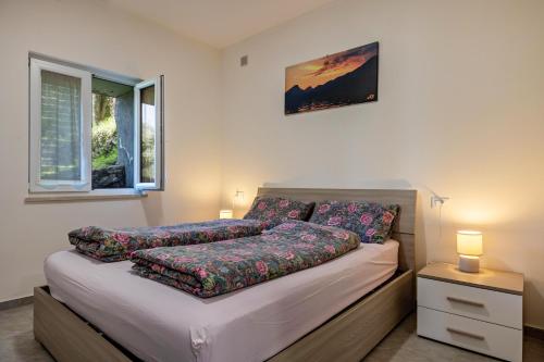 a bed with pillows on it in a bedroom at Casa Maria Lake View in Brenzone sul Garda