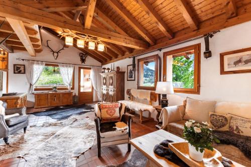 un soggiorno arredato con soffitto in legno di Chalet Chesa Collina with Sauna a La Punt-Chamues-ch