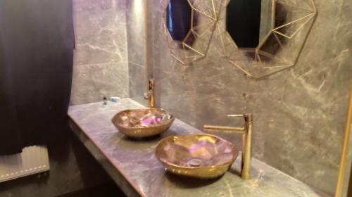 a bathroom with two copper sinks on a counter at Private Luxury Club in Poznań