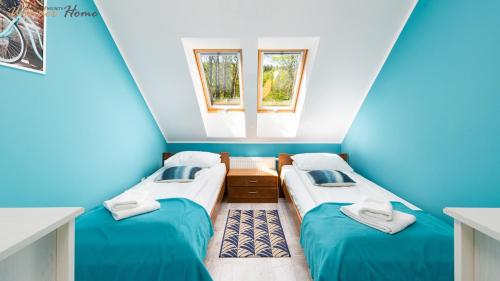Wonder Home - Apartamenty z prywatnymi saunami, w zielonej części Karpacza في كارباش: سريرين في غرفة بها نافذتين