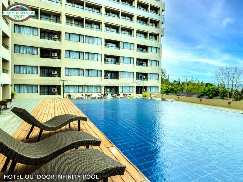un hotel con piscina frente a un edificio en Canyon Woods Resort Club Tagaytay en Tagaytay
