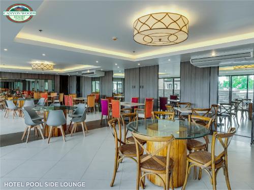 uma sala de jantar com mesas e cadeiras e um restaurante em Canyon Woods Resort Club Tagaytay em Tagaytay