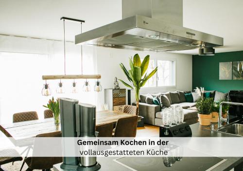 cocina y sala de estar con mesa en Ferienhausträume Oase Bodensee, en Kreuzlingen