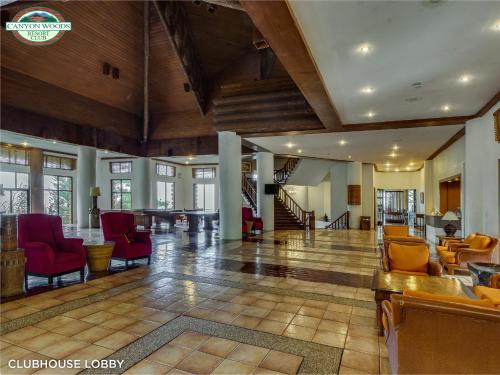 een grote lobby met rode stoelen en een tafel bij Canyon Woods Resort Club Tagaytay in Tagaytay