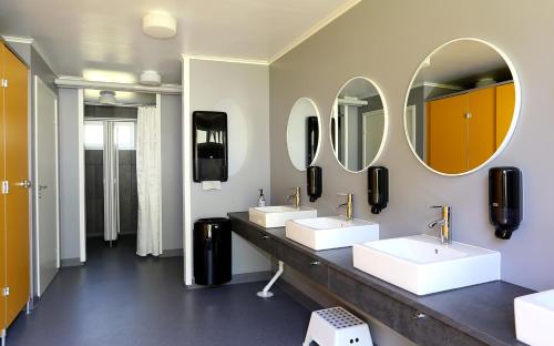 łazienka z 2 umywalkami i 2 lustrami w obiekcie Urshult Glamping w mieście Urshult