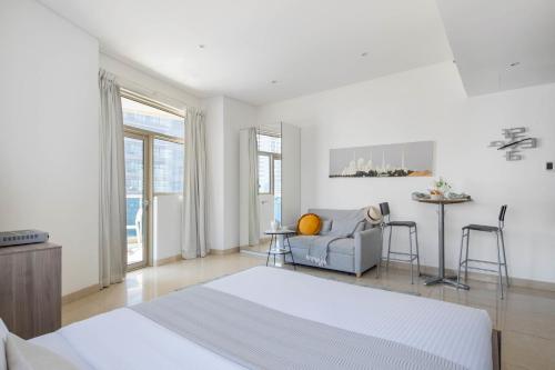 een witte slaapkamer met een bed en een bank bij Frank Porter - Yach Bay in Dubai