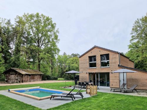 ein Haus mit Pool im Hof in der Unterkunft Waldhaus Tiedtke in Wedemark