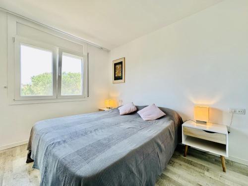 a bedroom with a large bed and two windows at Mimoses CostaBravaSi in Sant Feliu de Guíxols
