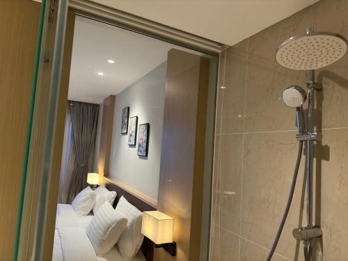 uma casa de banho com um chuveiro e uma cama com um espelho. em Helo!The Arena em Miếu Ông