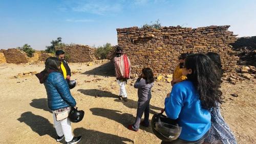 a group of people standing next to a brick wall at The Elite Castle in Jaisalmer