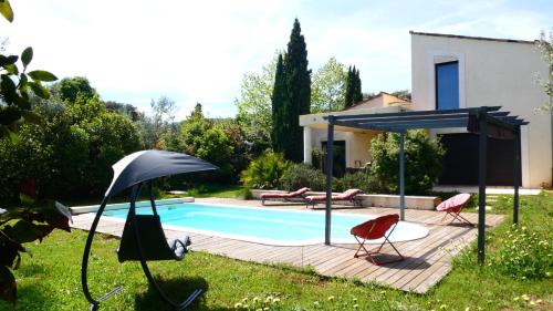 une piscine avec deux chaises et un parasol dans l'établissement Villa d'Architecte climatisée avec piscine, gîte classé 4 étoiles, à Biot
