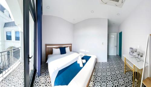 een hotelkamer met een bed en een balkon bij Beach Hotel Grand World (La La Homestay) in Phu Quoc