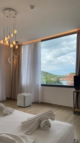a bedroom with a large window with a view at HOTEL DENOEL in Ksamil