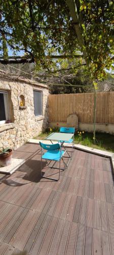 deux chaises et une table sur une terrasse en bois dans l'établissement Charmant studio indépendant dans la colline, à Eyguières